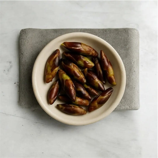 neutral textured background with bowl of balm of gilead buds in ceramic on stone counter gray, white, beige 