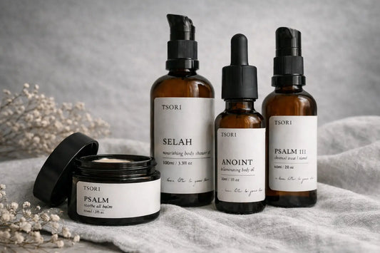 TSORI skincare collection displayed in amber glass bottles and a balm jar on neutral linen.