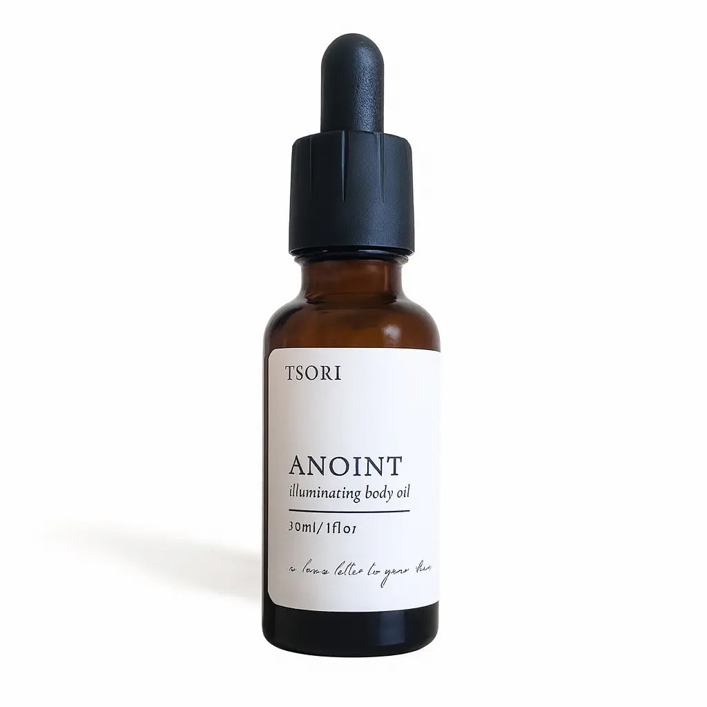 Bottle of Lune Noire illuminating body oil by Tsori on a textured surface with a white background