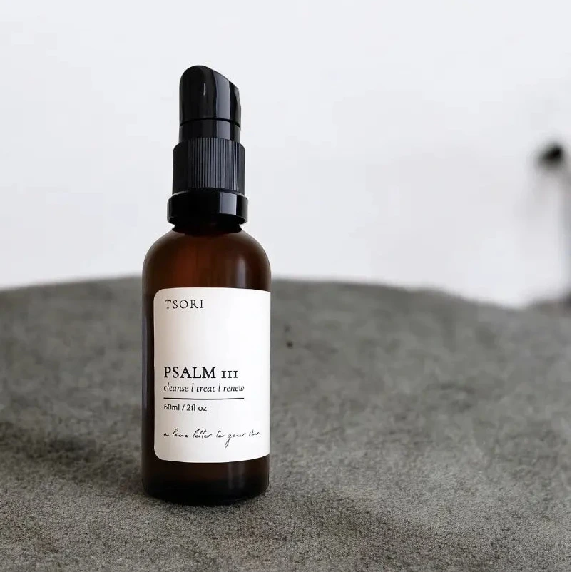 Bottle of Tsori Psalm III skincare serum on a textured surface with a neutral background