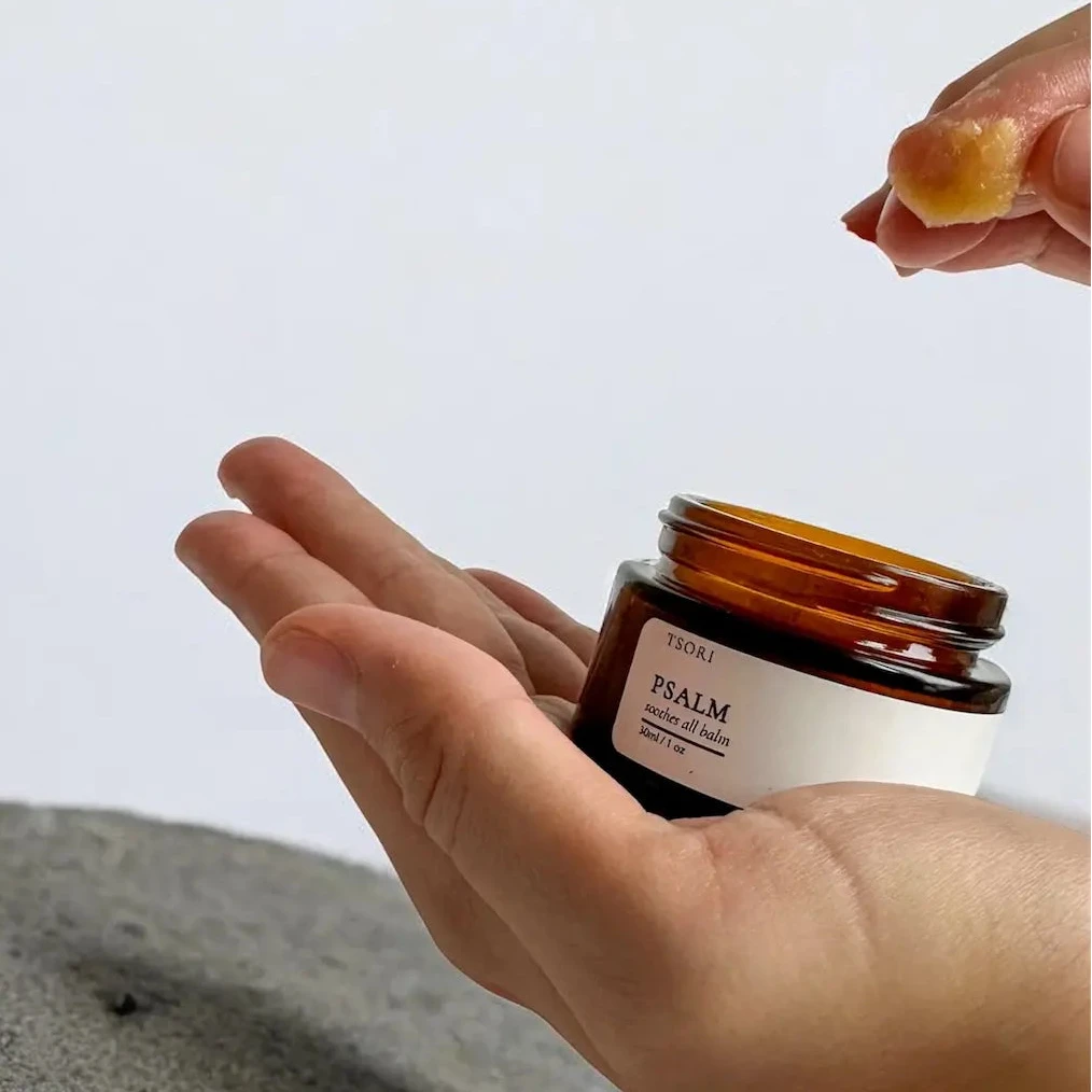 Hand holding a small jar labeled 'PSALM' with a blurred background