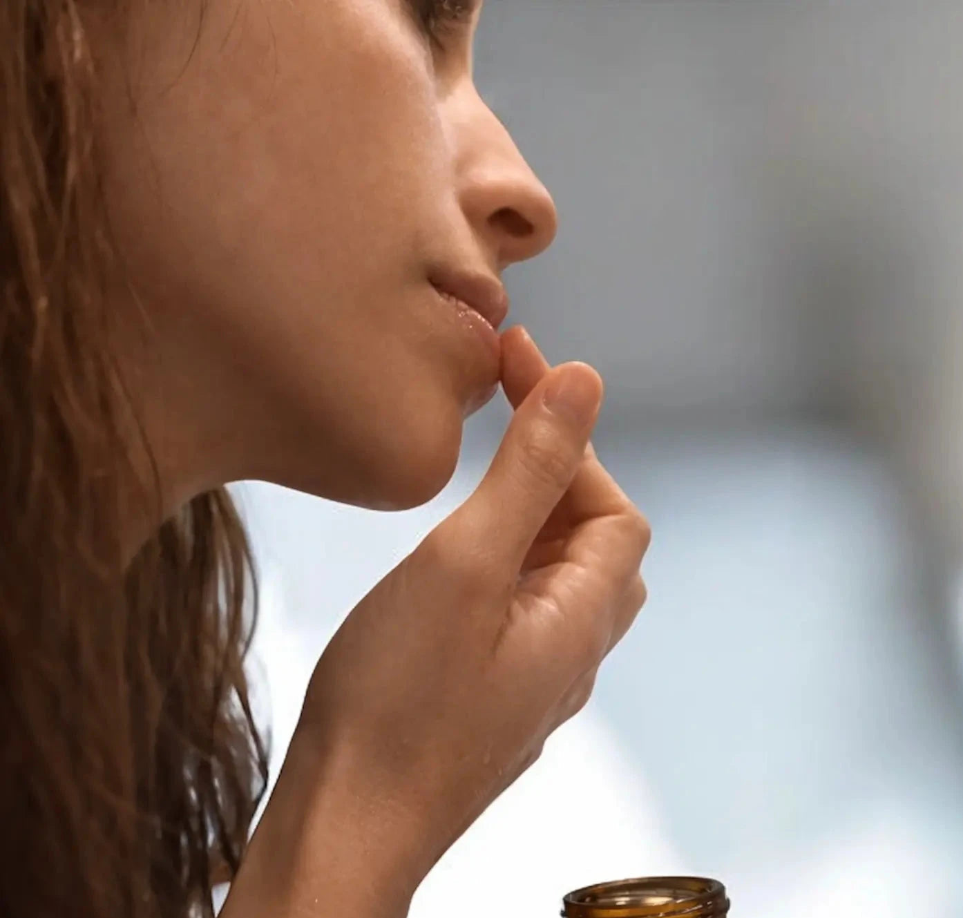 Woman with hand on chin, contemplating, with a blurred background