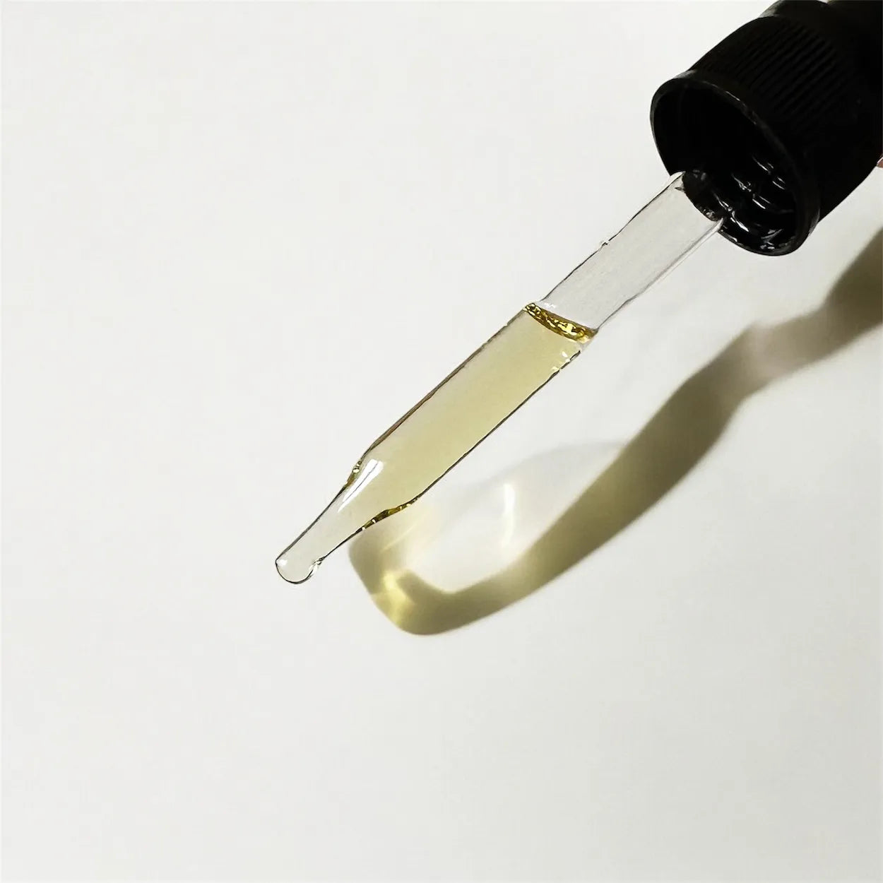 Dropper with a small amount of liquid on a white background
