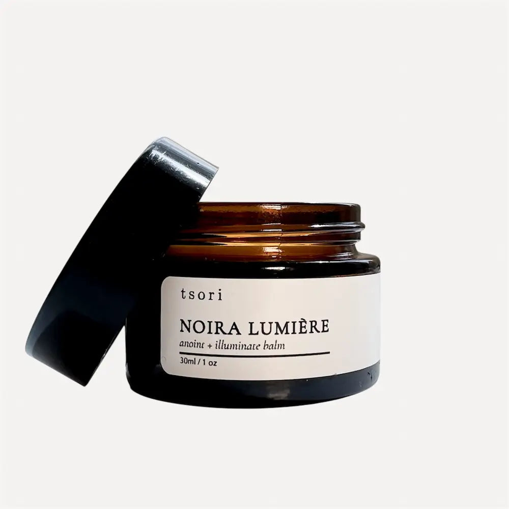 Jar of tsori Noira Lumiere balm with black lid on a white background