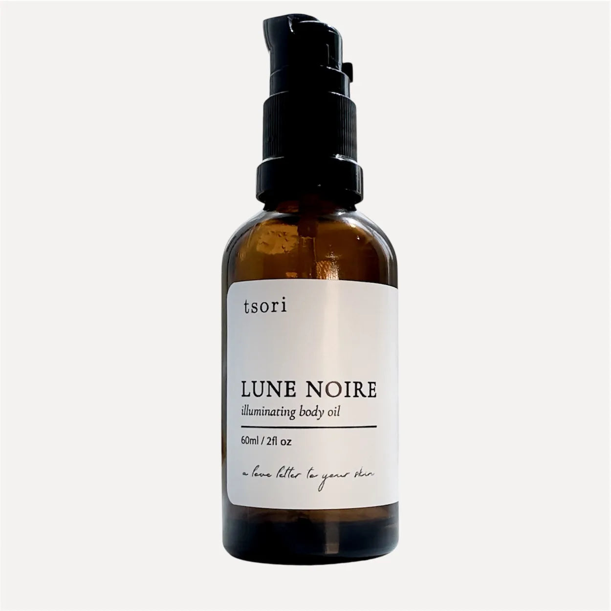 Pump bottle of tsori Lune Noire illuminating body oil on a white background