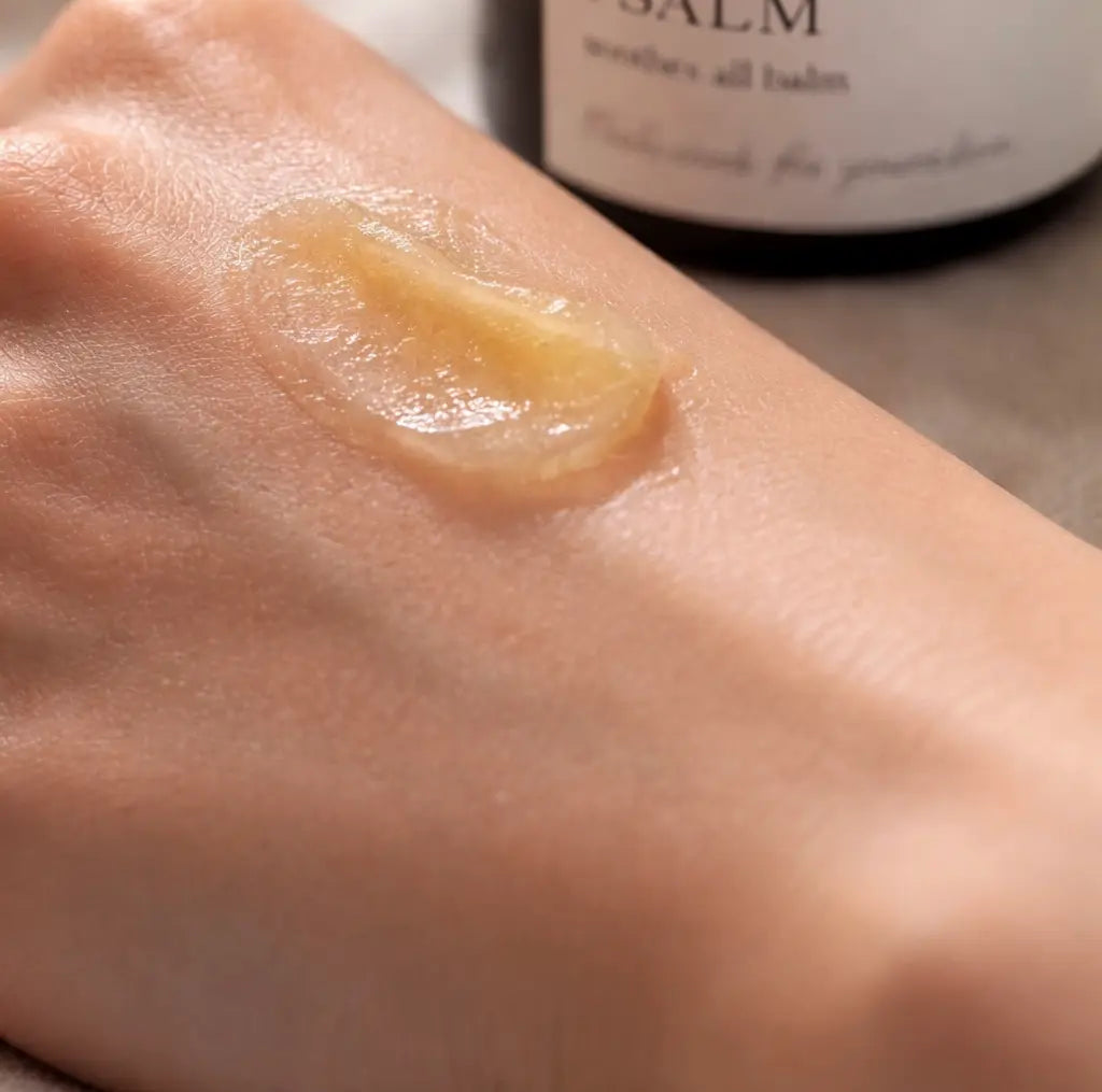 Balm applied to a hand with a bottle labeled 'SALM' in the background.